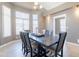 Open dining room featuring a wooden table, chandelier and large windows at 10228 E Carol Ave, Mesa, AZ 85208