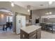 Spacious kitchen featuring a center island, white refrigerator and view into a dining area at 10228 E Carol Ave, Mesa, AZ 85208
