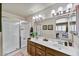 Bathroom with double sinks, tile floor, glass shower, and bright lighting at 10347 W Mohawk Ln, Peoria, AZ 85382