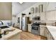 Well lit kitchen with white cabinets, stainless appliances, and breakfast nook in background at 10347 W Mohawk Ln, Peoria, AZ 85382