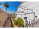 Backyard featuring a white fence, desert landscaping, and hardscape walkway leading to the gate at 1042 E Utopia Rd, Phoenix, AZ 85024