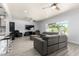 Spacious living room with modern gray couches, a ceiling fan, and bar seating to the kitchen at 1042 E Utopia Rd, Phoenix, AZ 85024