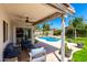 Covered patio area with comfortable seating, ceiling fan, and views of the landscaped backyard and pool at 1042 E Utopia Rd, Phoenix, AZ 85024
