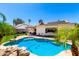 Backyard pool area featuring lush landscaping, rock features, solar panels and patio seating at 1042 E Utopia Rd, Phoenix, AZ 85024