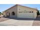Shot of the home showing a two-car garage, arched entryway, and desert landscaping at 1051 S 81St Way, Mesa, AZ 85208