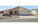 Close-up of the home featuring a two-car garage, arched entry way, and desert landscaping at 1051 S 81St Way, Mesa, AZ 85208