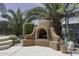 Outdoor fireplace and cooking area surrounded by desert landscaping and palm trees at 1123 E Shepherds Way, Casa Grande, AZ 85122