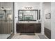 Bright bathroom features a large mirror, stone countertops, dark wood cabinets and a glass shower at 1221 E Paseo Way, Phoenix, AZ 85042