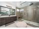Sleek bathroom with glass enclosed shower, neutral tile and granite countertops at 1221 E Paseo Way, Phoenix, AZ 85042