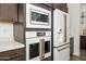 Modern kitchen appliances featuring stainless steel microwave, oven, and a white refrigerator with brass handles at 1221 E Paseo Way, Phoenix, AZ 85042
