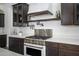 Stylish kitchen featuring a stainless steel range, quartz countertops, and dark wood cabinets at 1221 E Paseo Way, Phoenix, AZ 85042