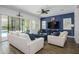 Stylish living room featuring a blue accent wall, plush seating, and access to the outdoor pool at 1221 E Paseo Way, Phoenix, AZ 85042