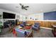 Comfortable living room with a television, ceiling fan, wood paneling and ample seating at 1221 E Paseo Way, Phoenix, AZ 85042