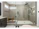 Modern shower with glass enclosure, neutral tiling, and a bench for added convenience at 1221 E Paseo Way, Phoenix, AZ 85042