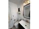 Modern bathroom with a green vanity, decorative mirror, and convenient toilet placement at 1222 E Almeria Rd, Phoenix, AZ 85006