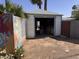 Exterior of garage with open door, colorful desert wall, and arid landscape at 1222 E Almeria Rd, Phoenix, AZ 85006