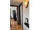 Hallway featuring hardwood floors, dark trim, and a vintage telephone alcove with period sconce at 1222 E Almeria Rd, Phoenix, AZ 85006