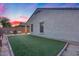 Backyard featuring manicured turf, a brick-lined border, and outdoor seating around a cozy fire pit, perfect for entertaining at 13657 W Paso Trl, Peoria, AZ 85383