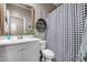 Well-lit bathroom featuring stylish black and white accents, a modern sink, and patterned shower curtain at 13657 W Paso Trl, Peoria, AZ 85383