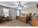 This inviting bedroom features a large wooden bed frame, neutral paint, carpet and abundant natural light from two windows at 13657 W Paso Trl, Peoria, AZ 85383