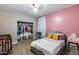 This bedroom features a bed with soft bedding, closet, pink wall, and a vanity for grooming at 13657 W Paso Trl, Peoria, AZ 85383