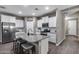 Modern kitchen boasts granite countertops, a center island with seating, and stainless steel appliances at 13657 W Paso Trl, Peoria, AZ 85383