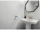 Half bathroom features a modern pedestal sink, hexagon mirror, and textured walls at 1414 E Cathedral Rock Dr, Phoenix, AZ 85048