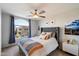 Cozy bedroom featuring a ceiling fan, tufted headboard, and bright window with neighborhood views at 1414 E Cathedral Rock Dr, Phoenix, AZ 85048