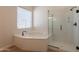 Bright bathroom features a soaking tub next to a glass enclosed shower, perfect for a relaxing retreat at 14771 W Columbus Ave, Goodyear, AZ 85395