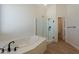 Bathroom with soaking tub, glass enclosed shower and view to hall at 14771 W Columbus Ave, Goodyear, AZ 85395
