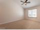 Cozy bedroom showcasing a ceiling fan, plush carpeting, and a large window at 14771 W Columbus Ave, Goodyear, AZ 85395