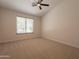 Bright, carpeted bedroom featuring a ceiling fan and large window at 14771 W Columbus Ave, Goodyear, AZ 85395