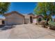 Charming single-story home featuring a three-car garage, neutral stucco, and low maintenance landscaping at 14771 W Columbus Ave, Goodyear, AZ 85395