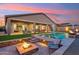 Backyard featuring a covered patio, sparkling pool, and a cozy fire pit, perfect for relaxation at 16417 W Fawn Dr, Goodyear, AZ 85338