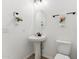 Charming powder room with a pedestal sink, oval mirror, and decorative towels at 16417 W Fawn Dr, Goodyear, AZ 85338