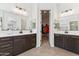 Bright bathroom with dual vanities, dark wood cabinets, tile floors, and an open closet at 16417 W Fawn Dr, Goodyear, AZ 85338