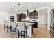 Kitchen island with bar seating, pendant lighting, and modern cabinetry, complemented by stainless appliances at 16417 W Fawn Dr, Goodyear, AZ 85338