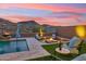 Backyard oasis with a pool, fire pit, and desert landscape creating a relaxing retreat at 16417 W Fawn Dr, Goodyear, AZ 85338