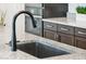 Close-up of a modern kitchen sink with a matte black faucet and granite countertops at 16417 W Fawn Dr, Goodyear, AZ 85338