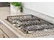 Close-up of a modern, stainless steel gas cooktop with granite countertops at 16417 W Fawn Dr, Goodyear, AZ 85338