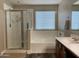 Bathroom featuring a glass-enclosed shower, soaking tub, and vanity with modern fixtures at 17344 W Adams St, Goodyear, AZ 85338