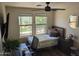 Sunlit bedroom features two windows, a ceiling fan, and a comfortable bed, offering a peaceful retreat at 17344 W Adams St, Goodyear, AZ 85338