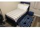 Cozy bedroom features a stylish blue bed frame, accent rug, and ottoman, creating a comfortable and inviting space at 17344 W Adams St, Goodyear, AZ 85338