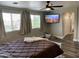 Spacious bedroom showcasing luxury vinyl plank flooring, a ceiling fan, and a wall-mounted TV at 17344 W Adams St, Goodyear, AZ 85338