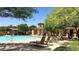 Community pool with lounge chairs surrounded by trees providing shade and relaxation at 17344 W Adams St, Goodyear, AZ 85338
