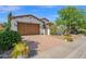 Charming home exterior with a two-car garage and brick driveway, complemented by well-manicured landscaping at 1768 E Grand Ridge Rd, Queen Creek, AZ 85140