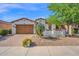 Charming single-story home featuring a two-car garage, well-maintained landscaping, and desert plants at 1768 E Grand Ridge Rd, Queen Creek, AZ 85140