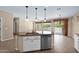 Modern kitchen island with stainless steel appliances, granite countertops, and white cabinets at 1768 E Grand Ridge Rd, Queen Creek, AZ 85140