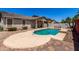 Inviting backyard with patio and pool, covered patio with stone supports, and lounge seating at 18041 W Ivy Ln, Surprise, AZ 85388