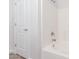 Bathroom featuring a tub with white tile, a door and a showerhead at 18041 W Ivy Ln, Surprise, AZ 85388